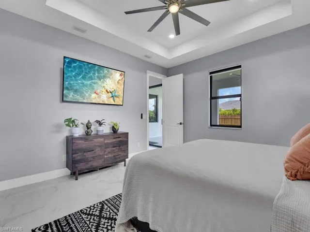 Bedroom with ceiling fan and a raised ceiling