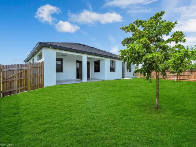 Rear view of house featuring a patio area and a yard