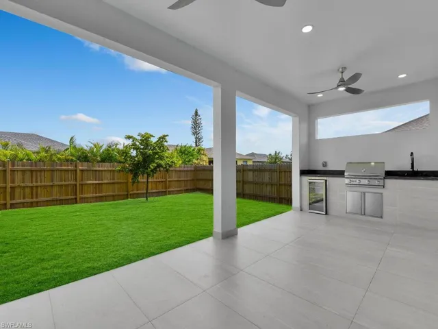 View of patio featuring ceiling fan, a grill, an outdoor kitchen, and sink