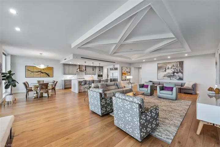 Living area with recessed lighting, light wood-type flooring, coffered ceiling, and beam ceiling
