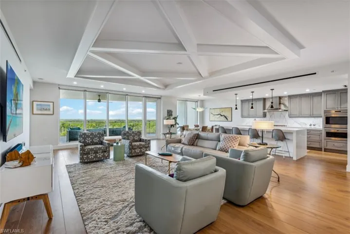 Living area featuring coffered ceiling, light wood finished floors, beamed ceiling, and recessed lighting
