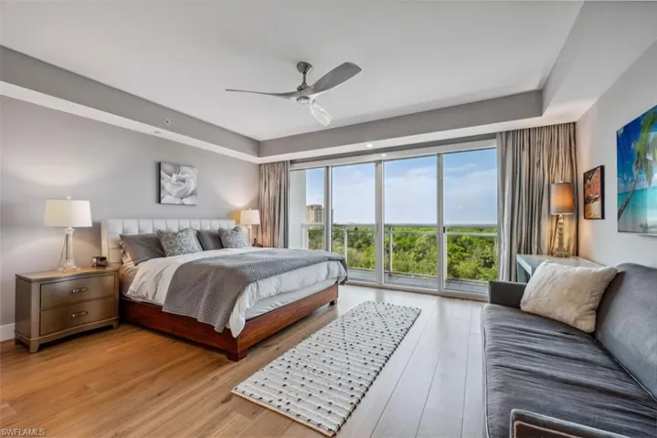 Bedroom featuring light wood finished floors, a ceiling fan, and access to exterior