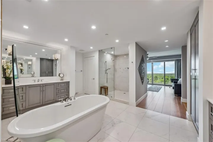 Bathroom featuring vanity, a soaking tub, a shower stall, recessed lighting, and a ceiling fan