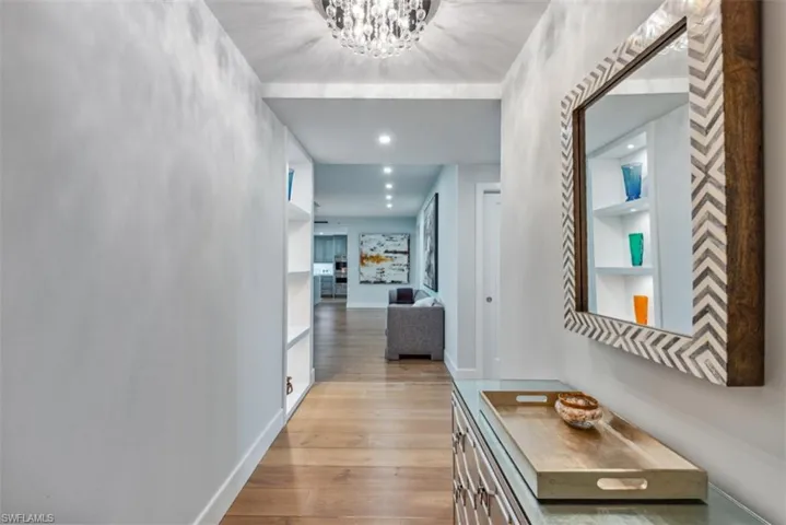 Hall with light wood-type flooring, recessed lighting, and a chandelier
