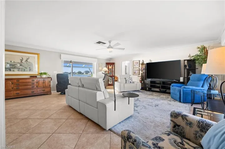 The family room features crown molding, decorative tile flooring on the diagonal, and stylish ceiling fan and lighting.