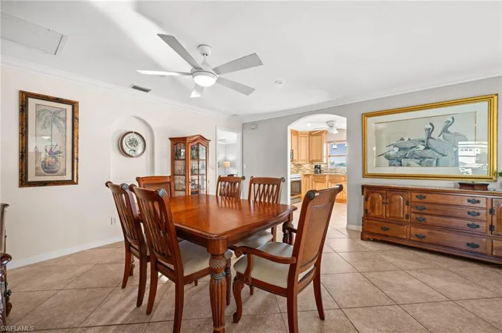The dining room also features beautiful tile on the diagonal, crown molding, and a stylish ceiling fan and light.