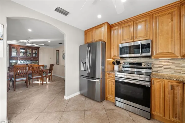Ideal for entertaining, the kitchen is steps away from the dining room. The new stainless appliances glisten.  Recessed lighting and pendant lighting are a bonus as is the crown molding and; 2 windows both with views.