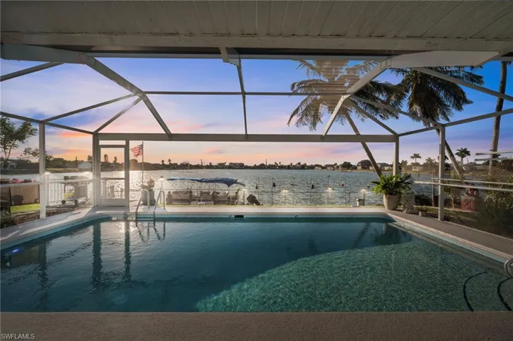 A stunning pool with decorative tile. Trex steps to the oversized dock. A concrete-block grill patio. And a lakefront sunset. Say wow!