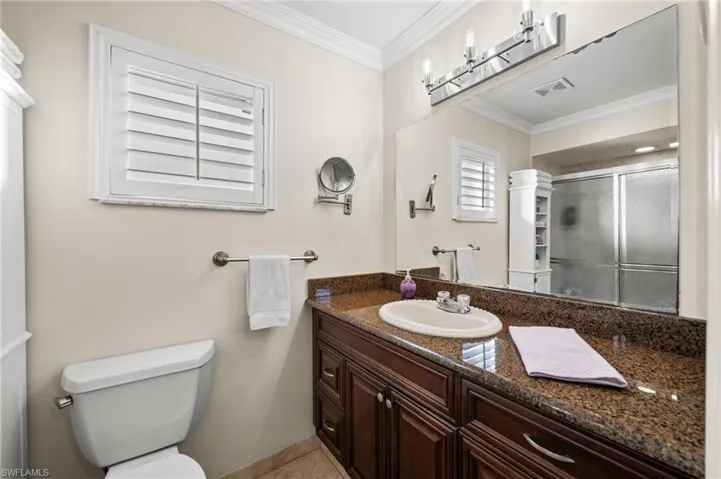 Quality cabinetry, granite countertops, plantation shutters, and a walk-in shower. The perfect primary bathroom.