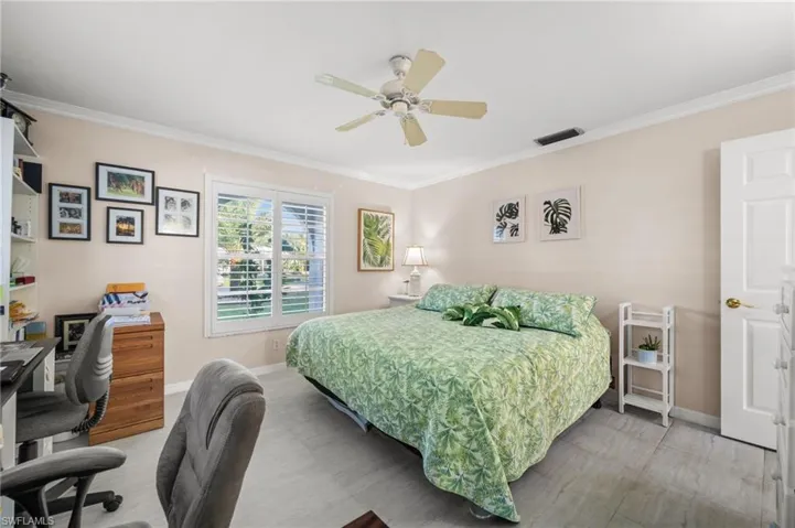 The guest bedroom offers updated flooring, crown molding, and room for a home office.