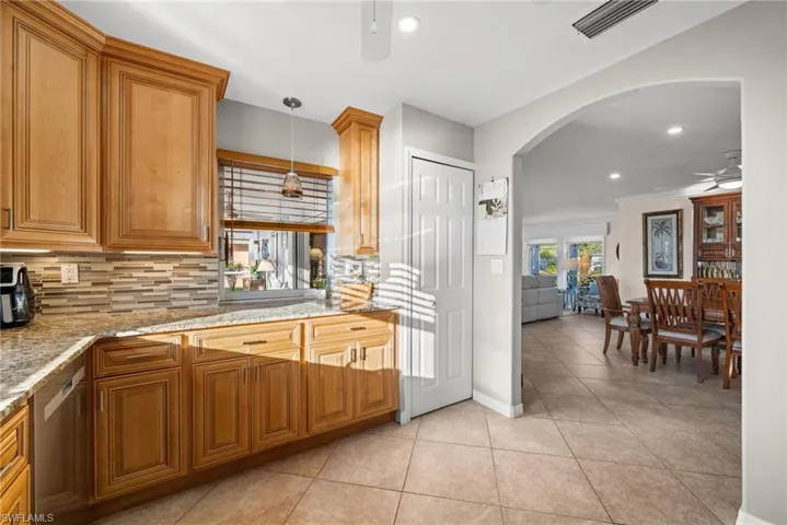 Enjoy the kitchen with a ceiling fan, the arched walkways, and decorative pendant lighting. A pantry - a must-have.