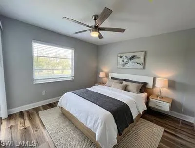 Bedroom with a ceiling fan and dark wood-style flooring