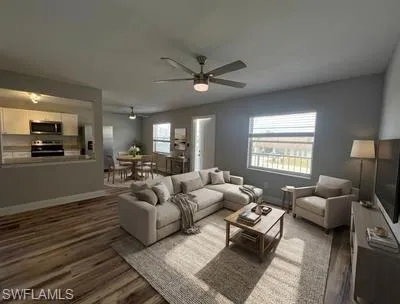 Living room featuring ceiling fan and dark wood finished floors