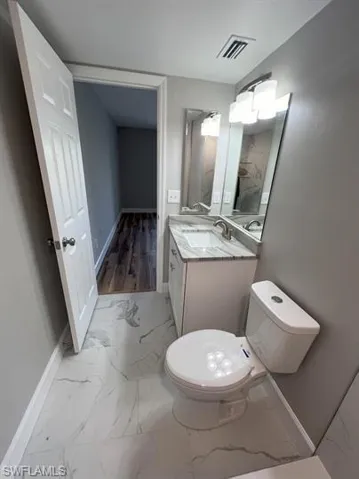 Bathroom with light marble finish floors and vanity