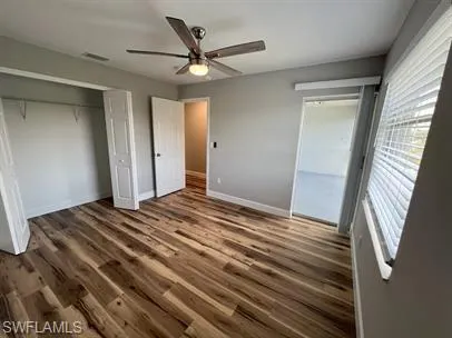 Unfurnished bedroom with a closet, wood finished floors, and a ceiling fan