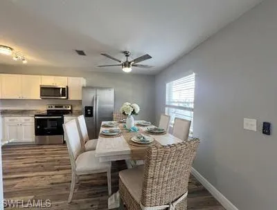 Dining room featuring ceiling fan and dark wood-type flooring