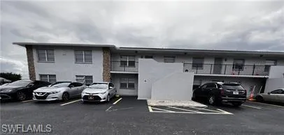 View of apartment building / complex featuring uncovered parking