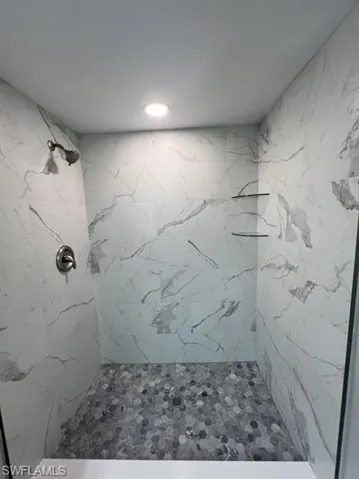 Bathroom featuring a marble finish shower