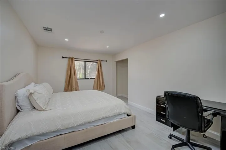Bedroom with an office area, recessed lighting, and light wood-style flooring