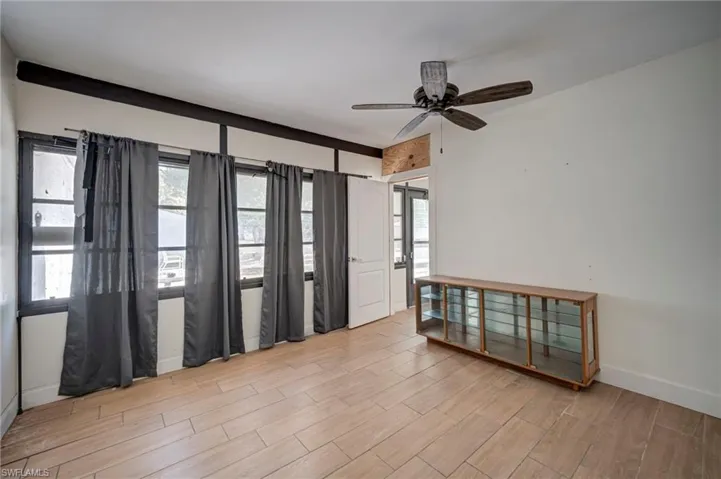 Empty room with wood tiled floors, ceiling fan, and plenty of natural light