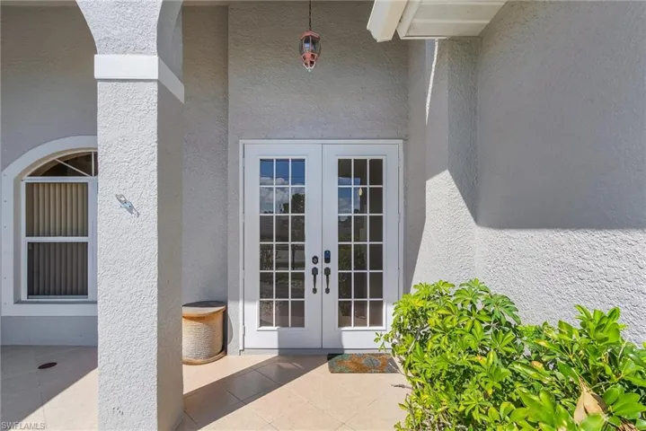 View of exterior entry featuring french doors and stucco siding