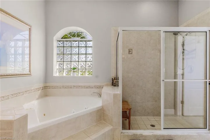 Bathroom with a stall shower and a tub with jets