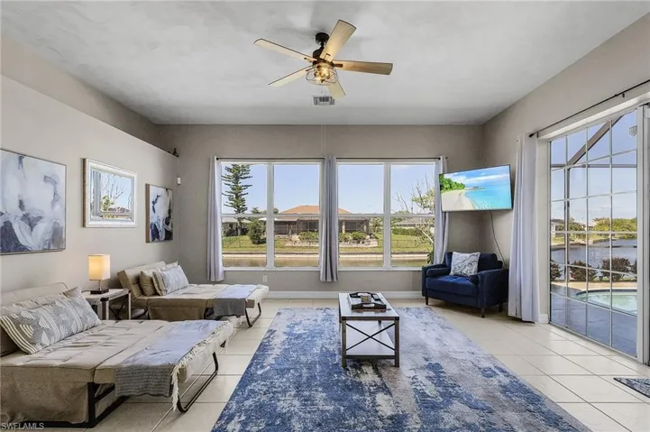 Living room with a ceiling fan and light tile patterned floors