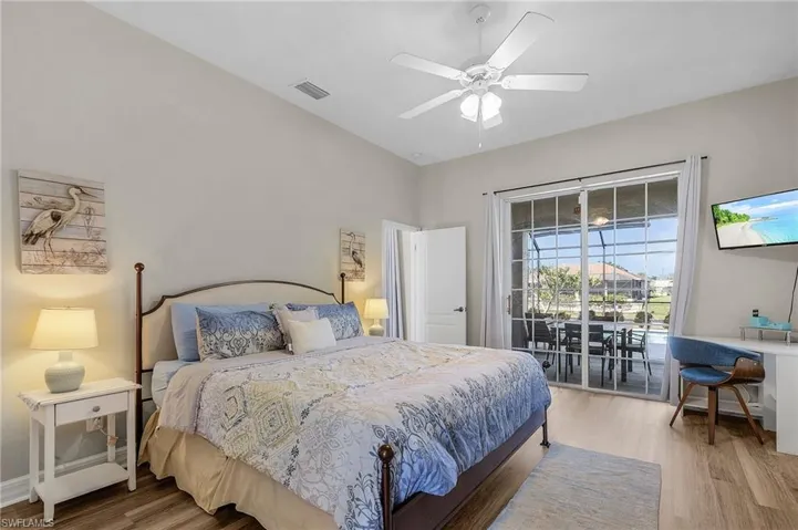 Bedroom with access to exterior, wood finished floors, and a ceiling fan