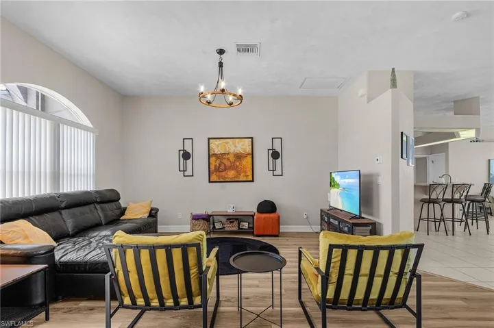 Living room featuring light wood-type flooring and a chandelier