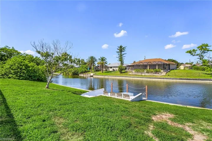 Dock with a water view, a lawn, and a residential view