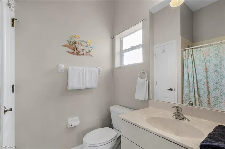 Full bathroom with vanity, a shower with shower curtain, and a ceiling fan