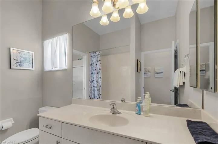 Full bathroom with vanity, curtained shower, and a chandelier