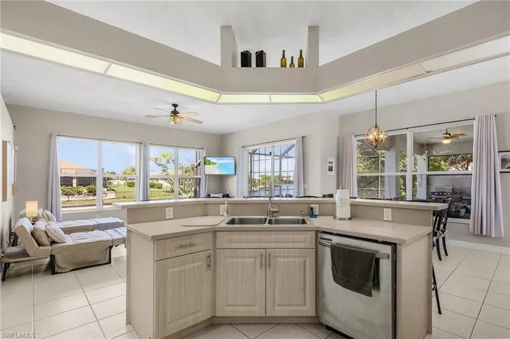 Kitchen with open floor plan, dishwasher, a ceiling fan, and light countertops