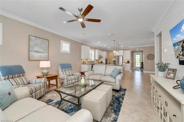 Living room featuring crown molding, and plenty of natural light