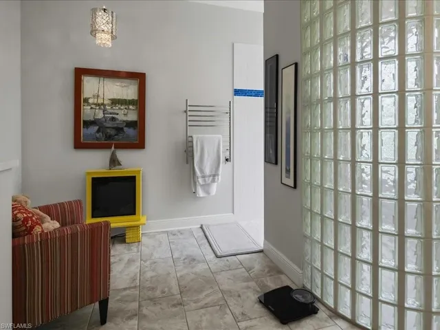Oversized glass block shower in bright primary bath.