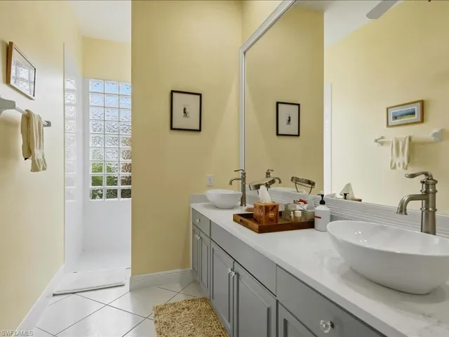 Renovated ensuite guest bathroom with double sinks and quartz countertops