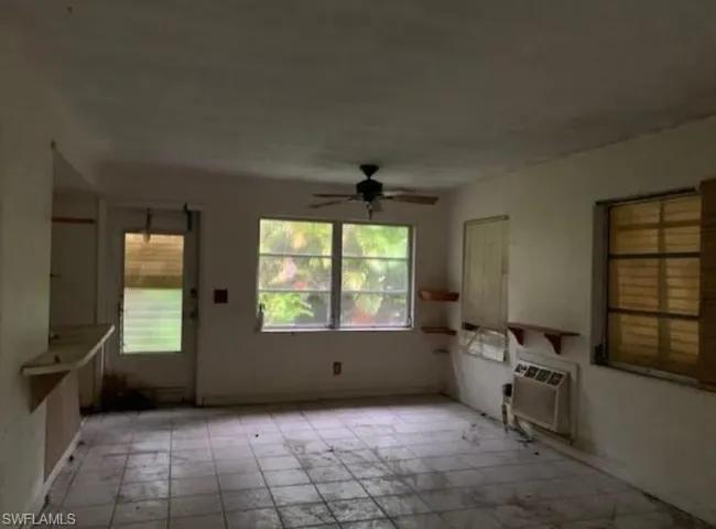 Unfurnished dining area featuring a wall unit AC and a ceiling fan