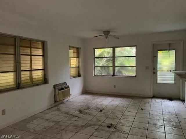 Unfurnished room with a ceiling fan and a wall mounted AC