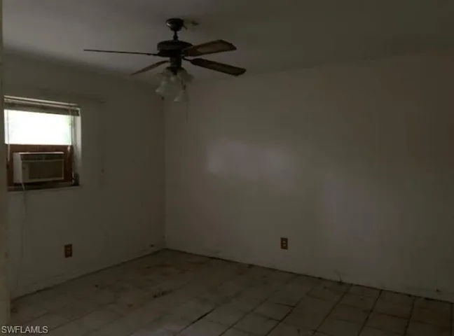 Unfurnished room featuring a ceiling fan and cooling unit