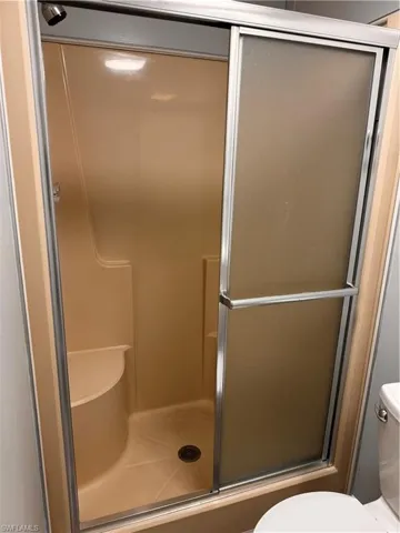 Full bath with toilet and a shower stall
