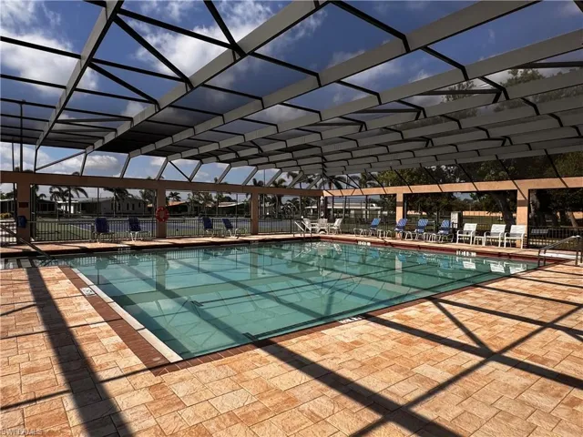 Community pool with a lanai, fence, and a patio