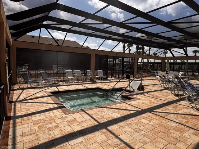 View of pool featuring a patio, a hot tub, and a lanai