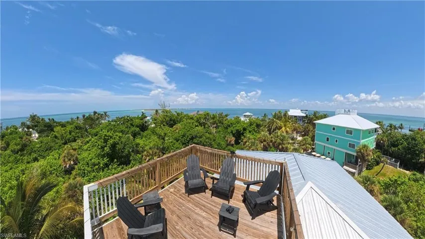 Rooftop deck featuring a natural wood-finish surface and vertical slat railing with expansive ocean horizons