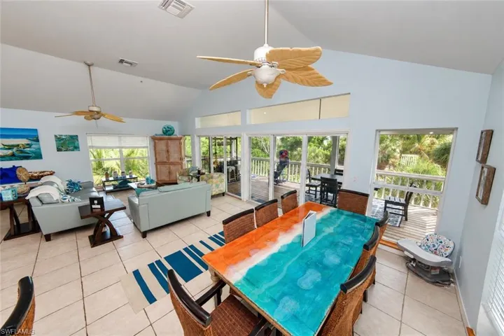 Vaulted ceilings with dual ceiling fans, ceramic tile flooring, and oversized sliding glass doors