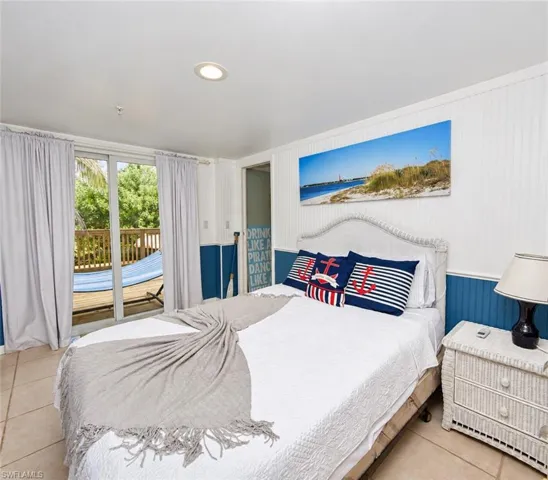 Beadboard wainscoting, tile flooring, recessed ceiling lighting, and sliding glass doors with access to an exterior deck