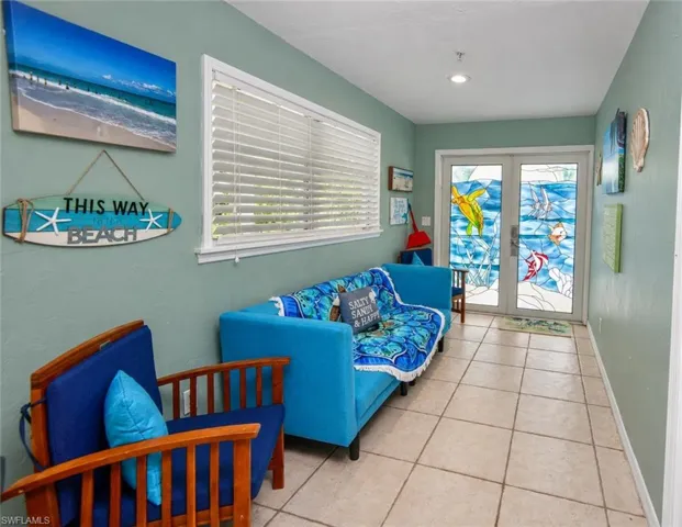 Double entry doors featuring custom stained glass inserts, complemented by large-format tile flooring and recessed lighting