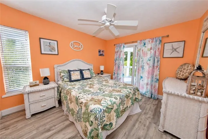 Wood-finish flooring, ceiling fan, and sliding glass doors with access to an exterior deck