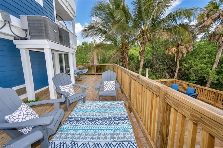 Elevated wooden deck with balustrade railings and blue horizontal lap siding