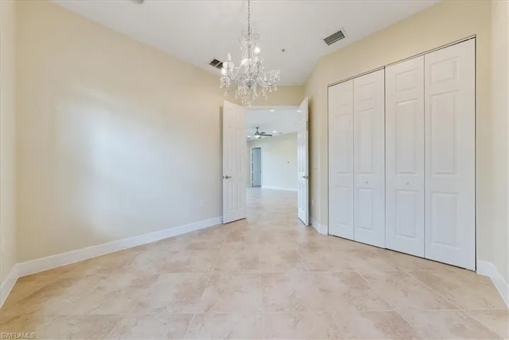 Unfurnished bedroom featuring a closet and a chandelier