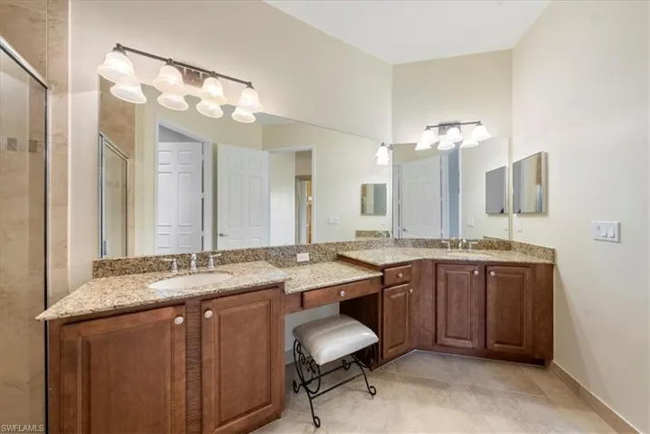 Bathroom featuring vanity, a shower with shower door, and tile patterned flooring